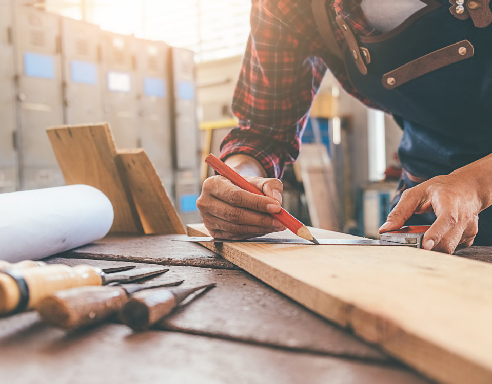 carpenter uses drill to install replacement window