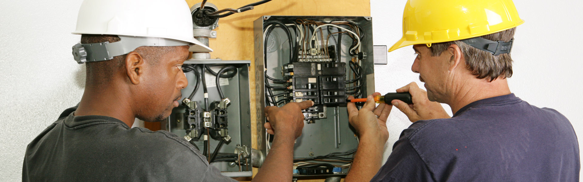 Electricians repairing breaker panel